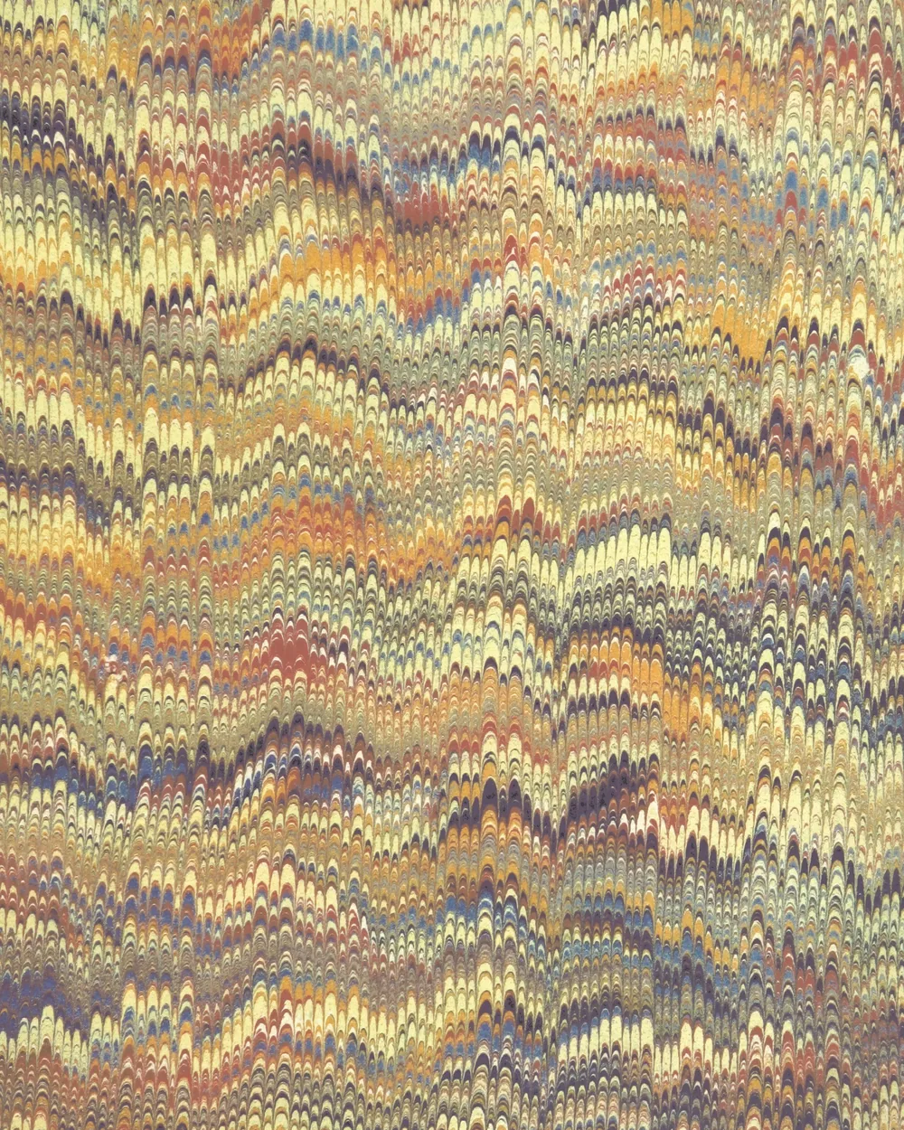 Hoja de papel marmoleado con un patrón de peine en tonos ocre, azul y crema, formado por hileras regulares de arcos.